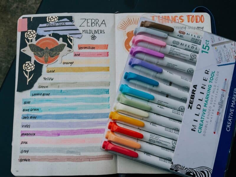 Beautiful image of a colorful bullet journal alongside a package of Zebra markers