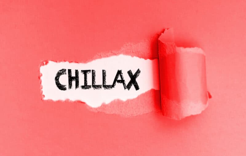 The word chillax written with a tear of pink paper revealing it