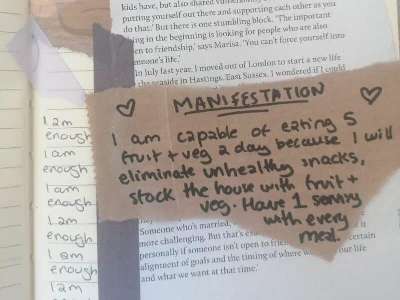A manifestation written in a journal with a message about healthy eating