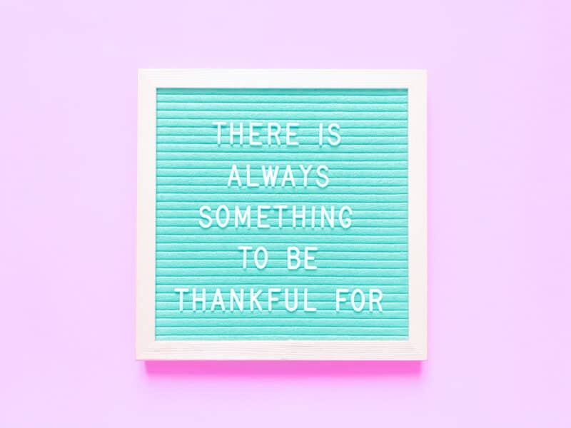 Blue Letterboard sign that says There is Always Something to Be Thankful for against a pink background