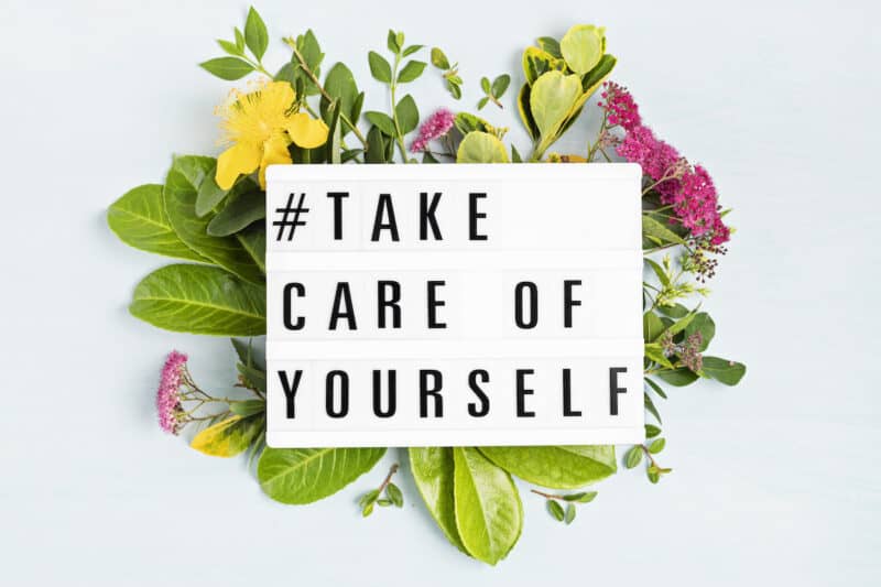 Lightbox on top of a flower arrangement with text that says # Take Care of Yourself